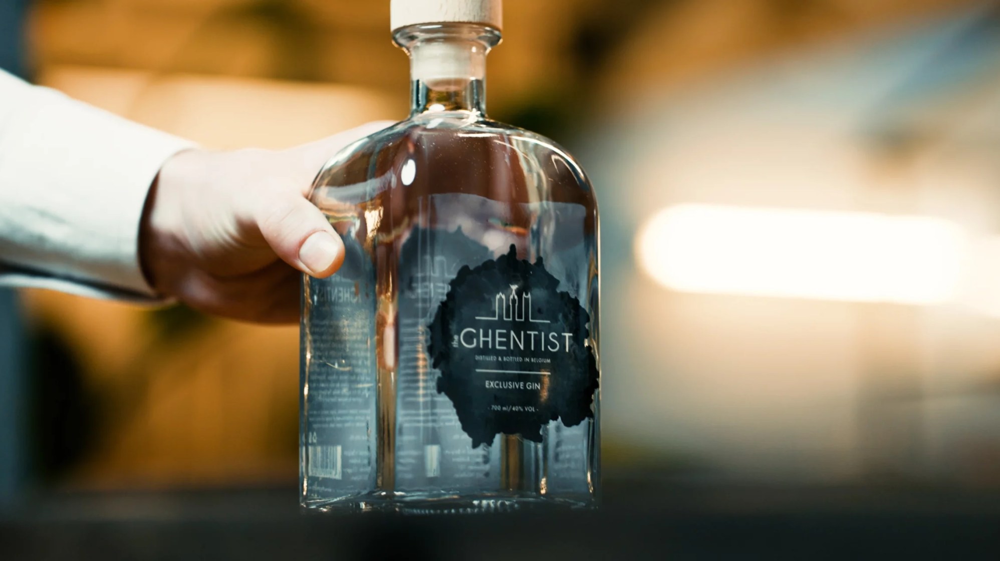 Ghentist gin bottle on wooden table with plants
